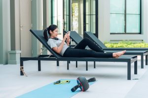 woman using smartphone relaxing after workout min